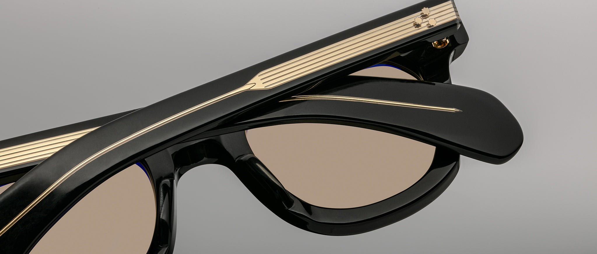 Close-up of Jacques Marie Mage Vendome sunglasses showing gold accents and tan lenses, product viewed from the front.
