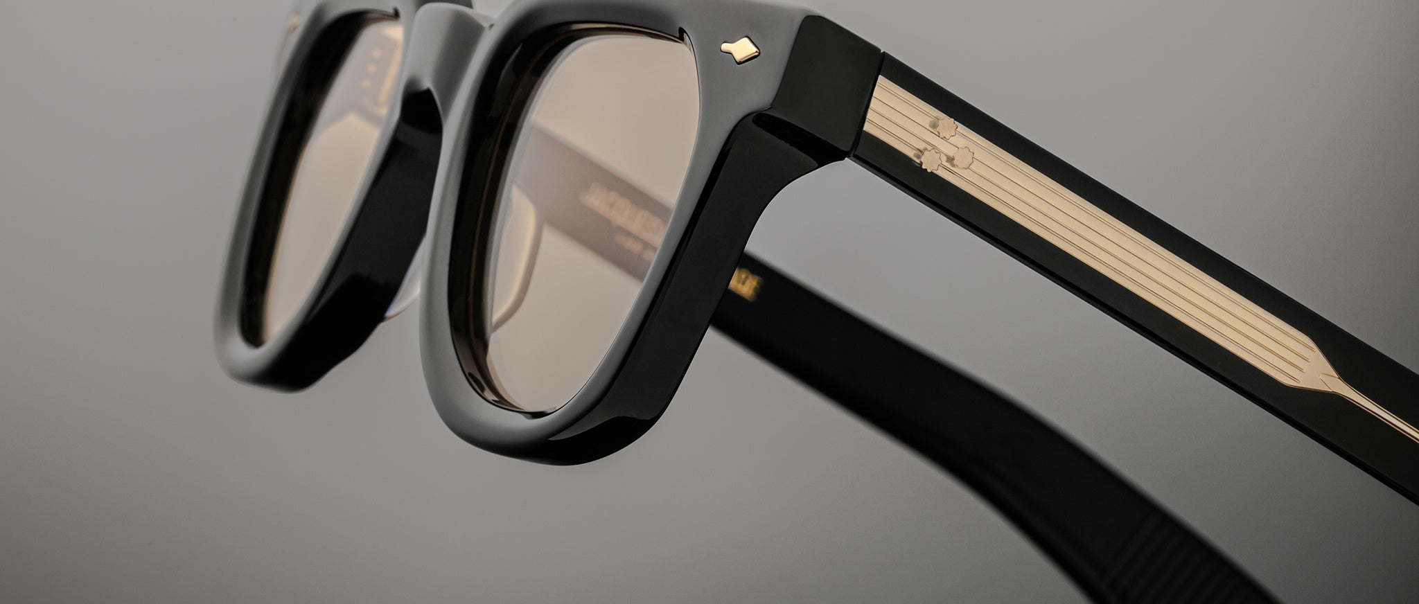 Jacques Marie Mage Vendome sunglasses, black frame with gold temples, minimalist design, front angle view.