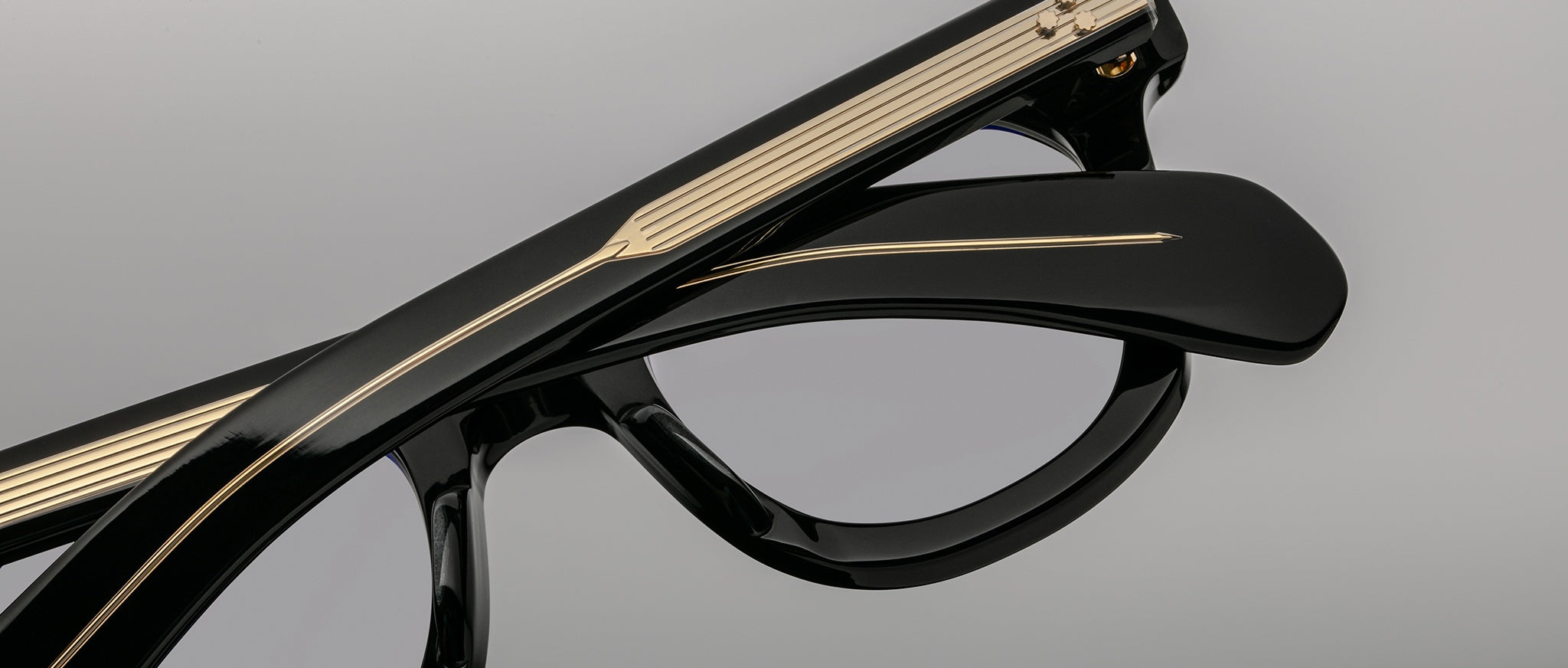 Close-up of Jacques Marie Mage Vendome black eyeglasses, featuring gold-detailed arms, front and side view visible.