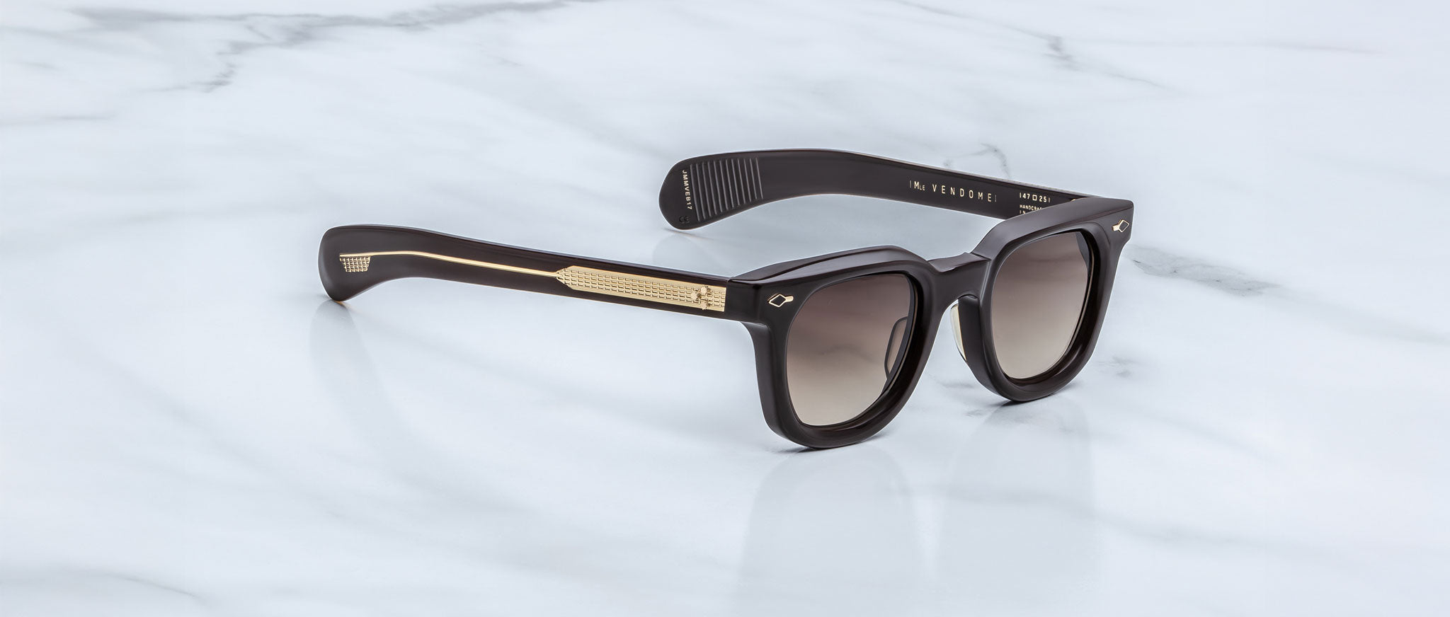 Jacques Marie Mage Vendome sunglasses with gold accents and dark lenses, viewed from above.