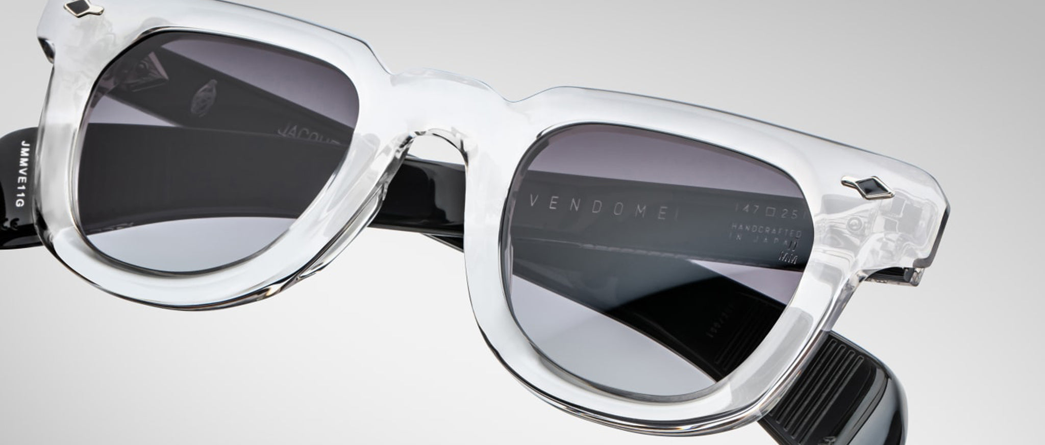 Jacques Marie Mage Vendome sunglasses in clear acetate, UV-protective dark lenses, black arms; front angled view.