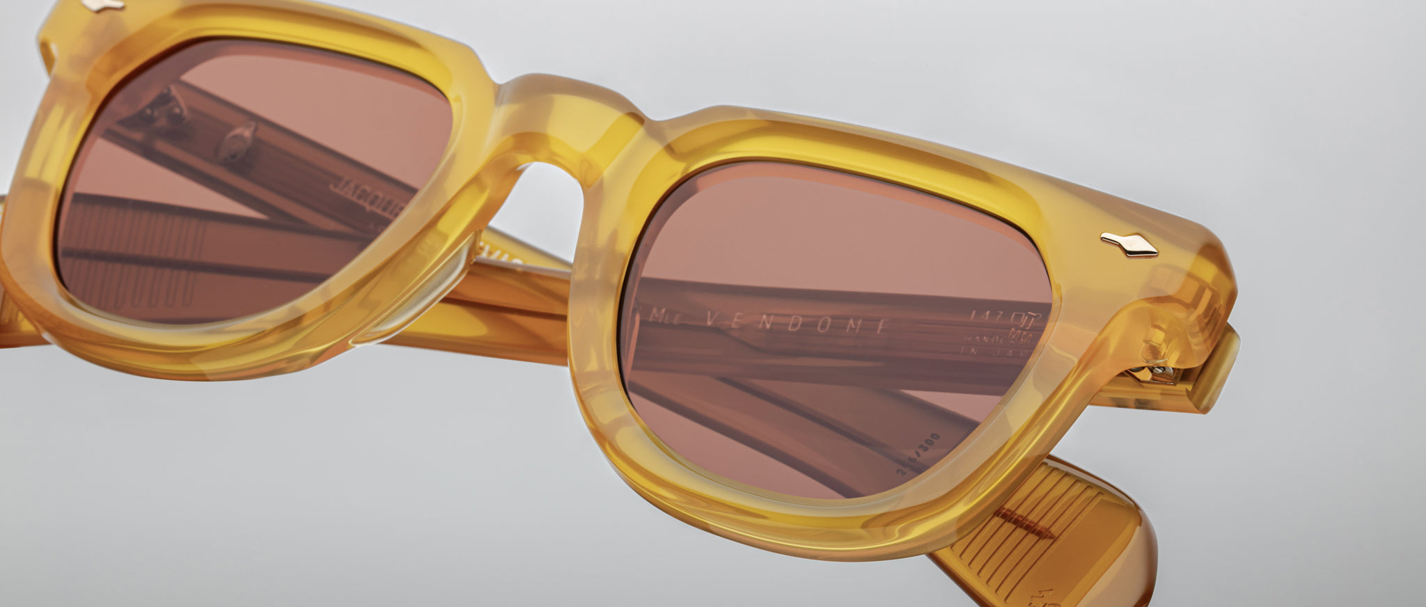 Close-up of Jacques Marie Mage Vendome yellow translucent sunglasses with mirrored brown lenses, front view.