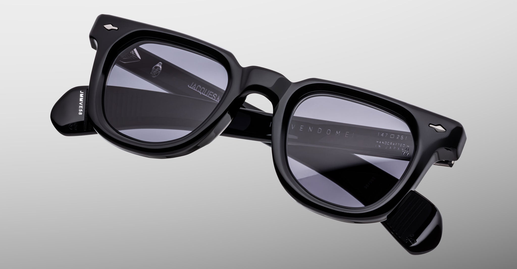 The Jacques Marie Mage Vendome sunglasses by Jacques Marie Mage feature handcrafted black rectangular thick frames and dark tinted lenses, made in Japan, displayed on a plain light gray background.