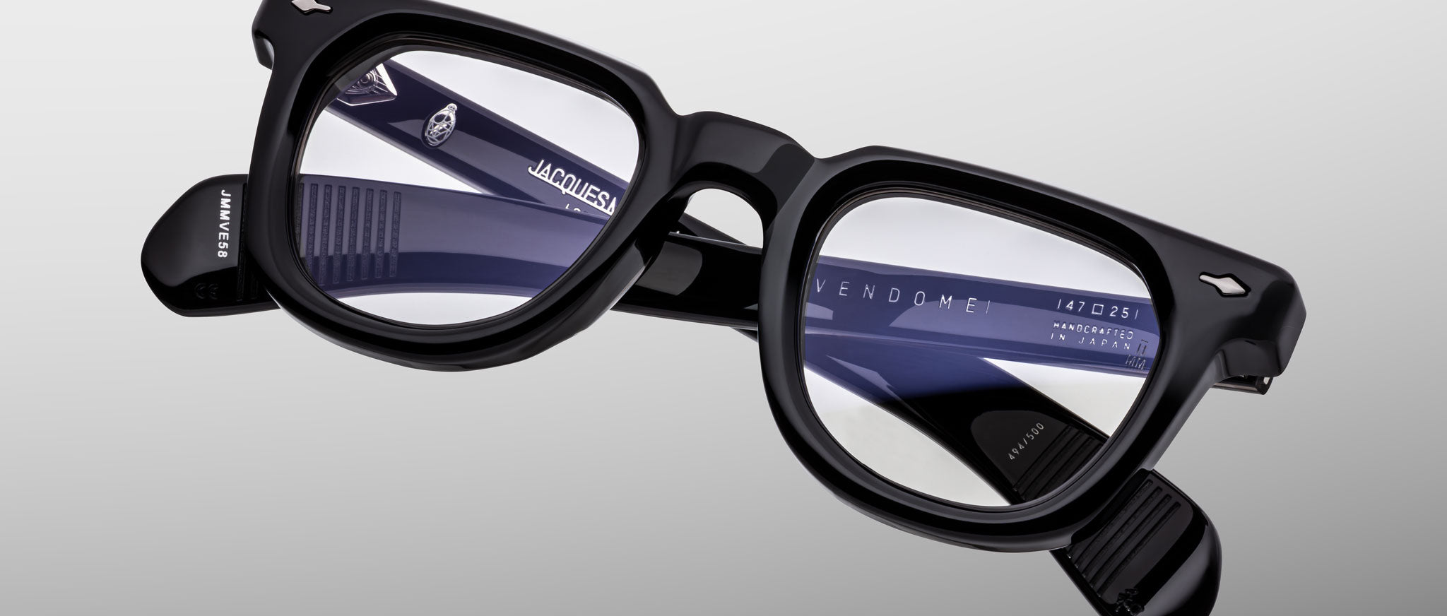 Close-up of Jacques Marie Mage Vendome eyeglasses, black frames, clear lenses, brand name and model on inner arms, side view.