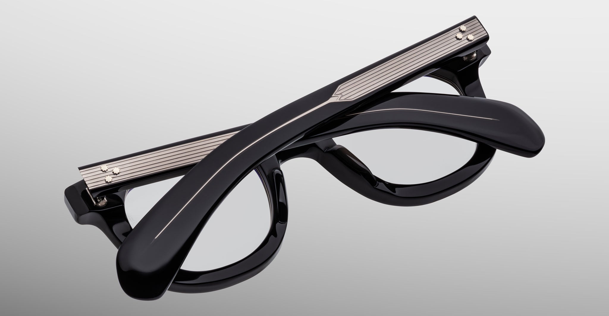The Jacques Marie Mage Vendome black optical frames, featuring metallic accents, are shown folded on a light gray background. Handcrafted in Japan, these eyeglasses by Jacques Marie Mage offer timeless style and artisanal quality.