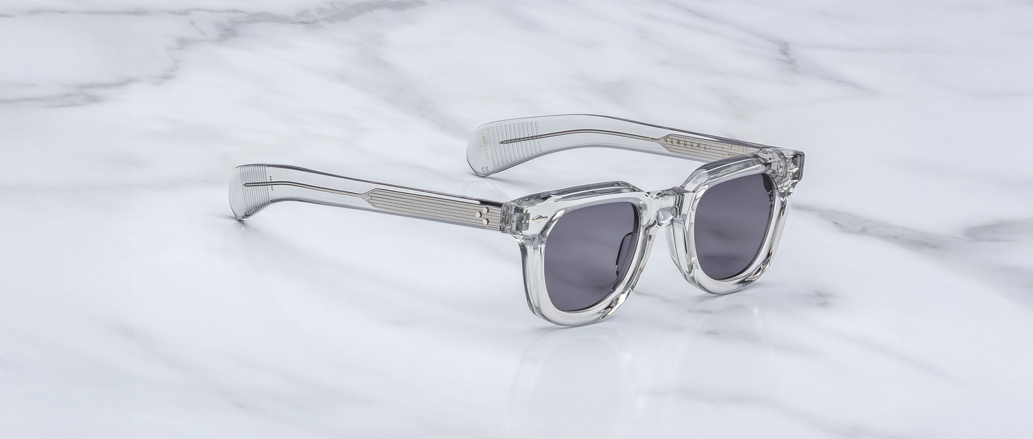 Jacques Marie Mage Vendome sunglasses with clear frames and dark lenses, top view.