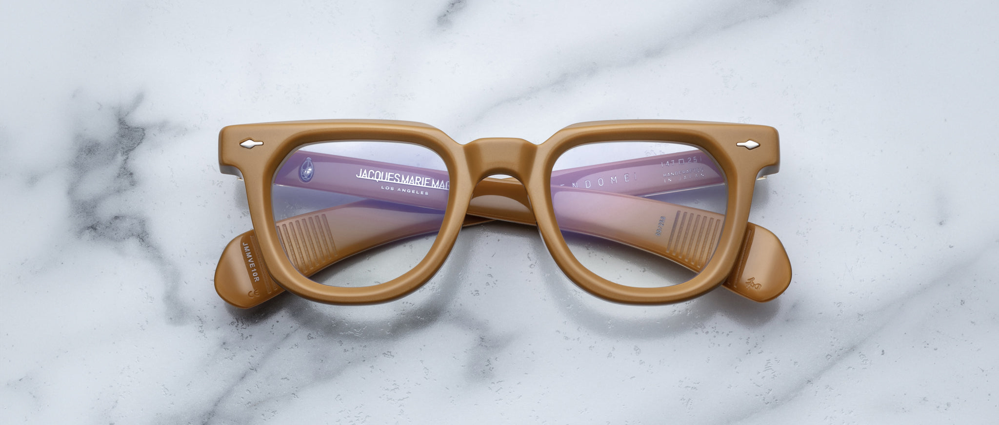 Jacques Marie Mage Vendome tan rectangular eyeglasses with clear lenses, top view, product on display.