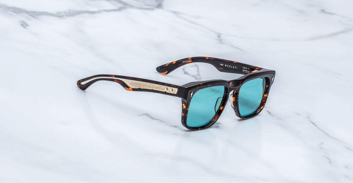 Jacques Marie Mage Wesley sunglasses with teal lenses and gold accents, front view.