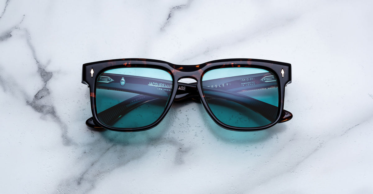 Jacques Marie Mage Wesley sunglasses with blue lenses and rounded arms, shown from above.
