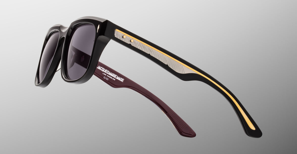 Jacques Marie Mage Wesley black sunglasses with gold and silver arms, shown from the front angle.