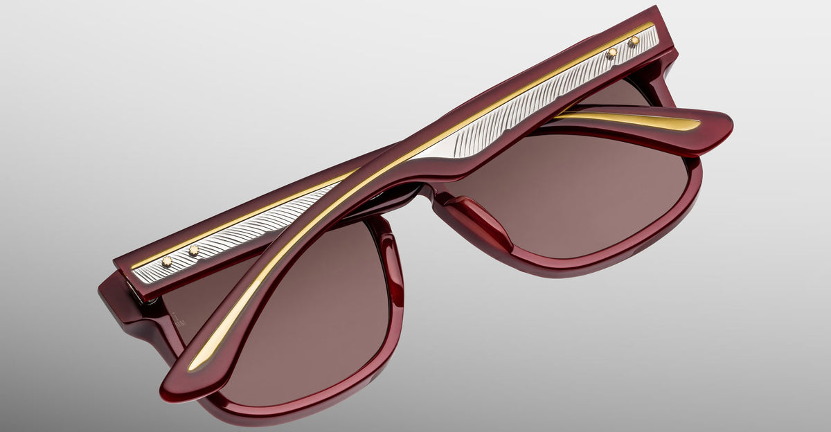 Jacques Marie Mage Wesley sunglasses, red frame with gold and silver accents, shown folded from a side view.