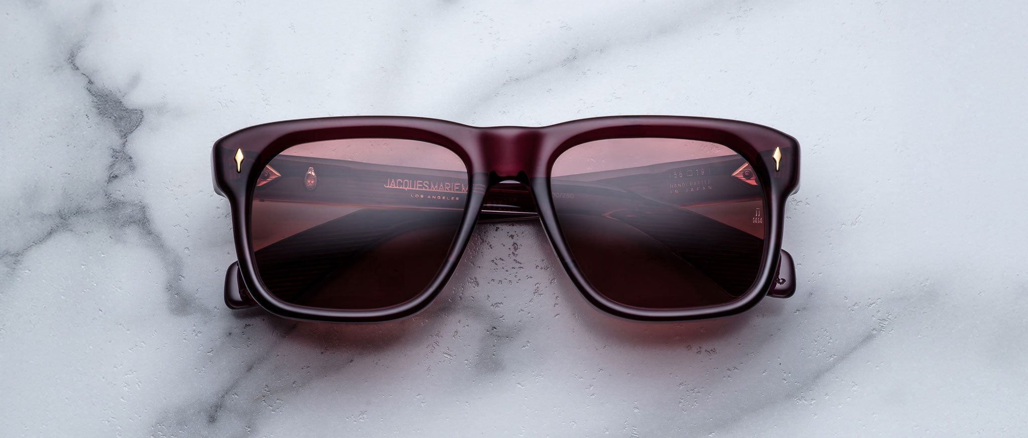 Jacques Marie Mage Yves dark red sunglasses with tinted lenses shown from above.