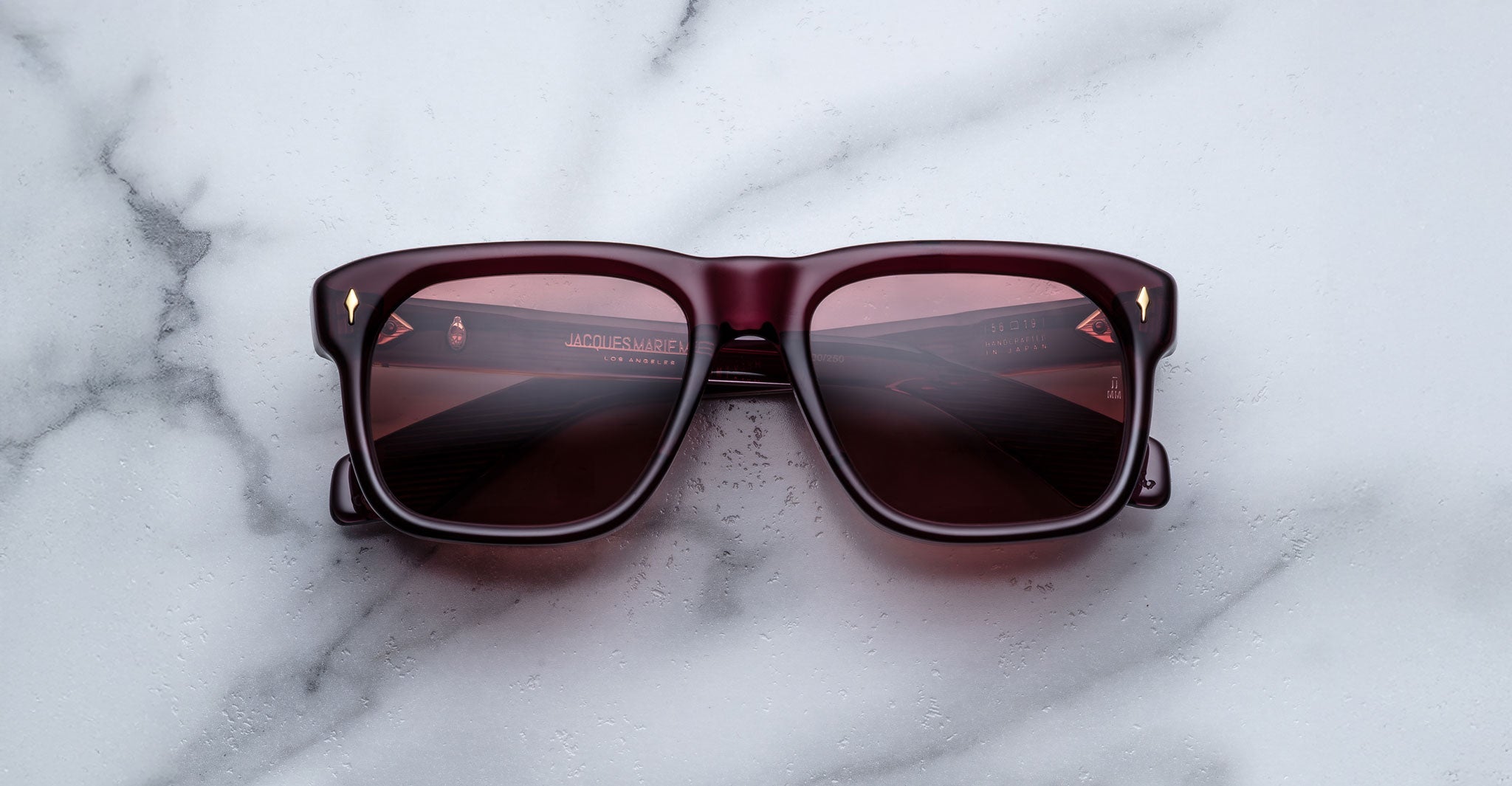 Jacques Marie Mage Yves dark red sunglasses with tinted lenses shown from above.