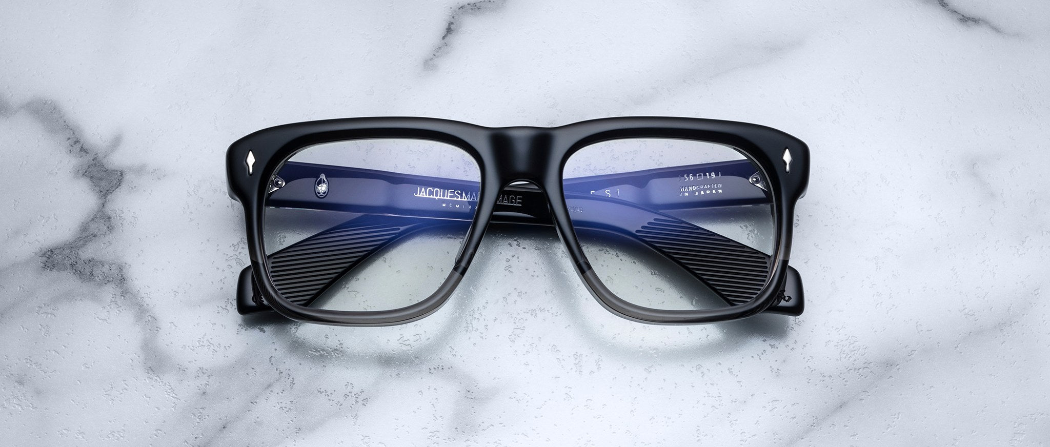 Jacques Marie Mage Yves black rectangular eyeglasses with glossy lenses, front view.
