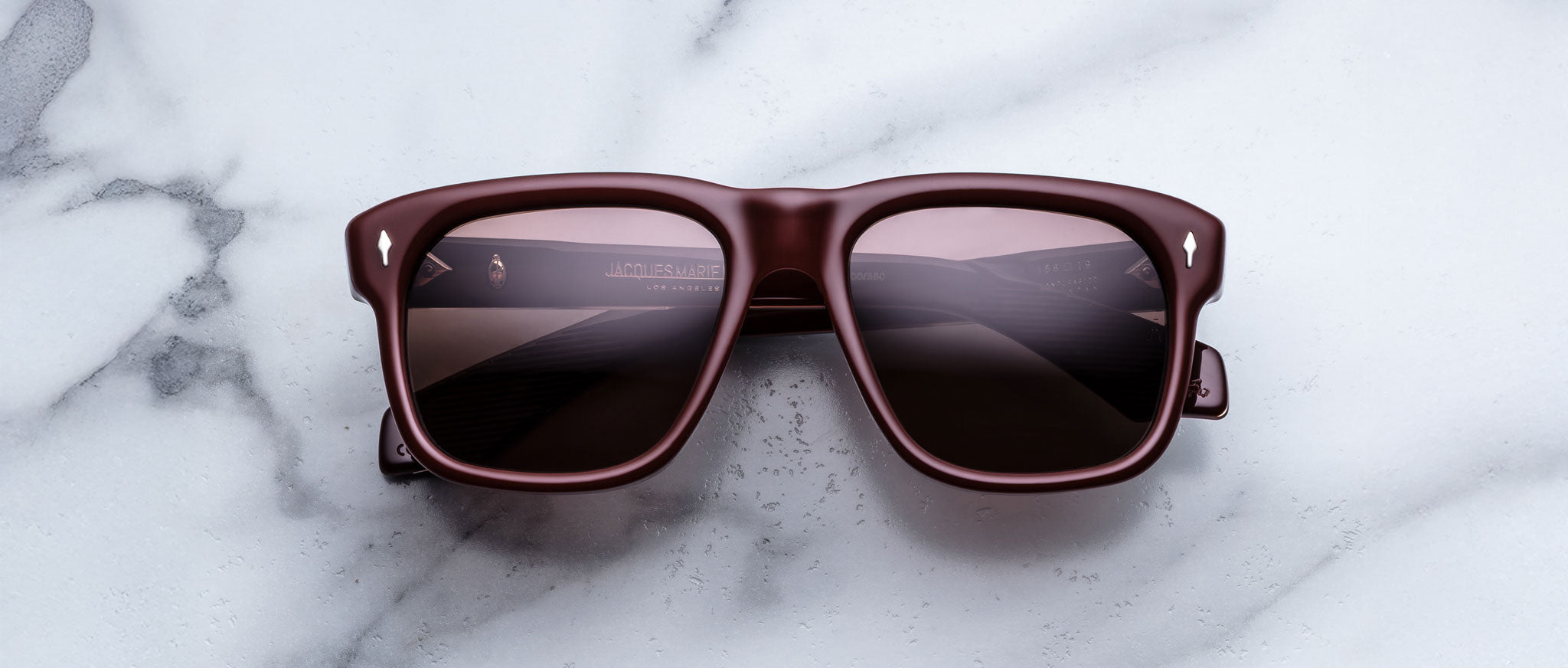 Jacques Marie Mage Yves in Bordeaux Empire sunglasses, rectangular deep red acetate frame with rose-tinted lenses and signature arrowhead rivets, front view