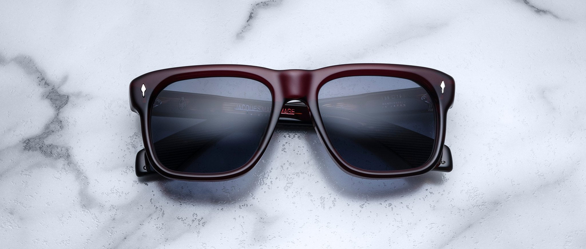 Jacques Marie Mage Yves sunglasses with square maroon frames and dark lenses, front view.