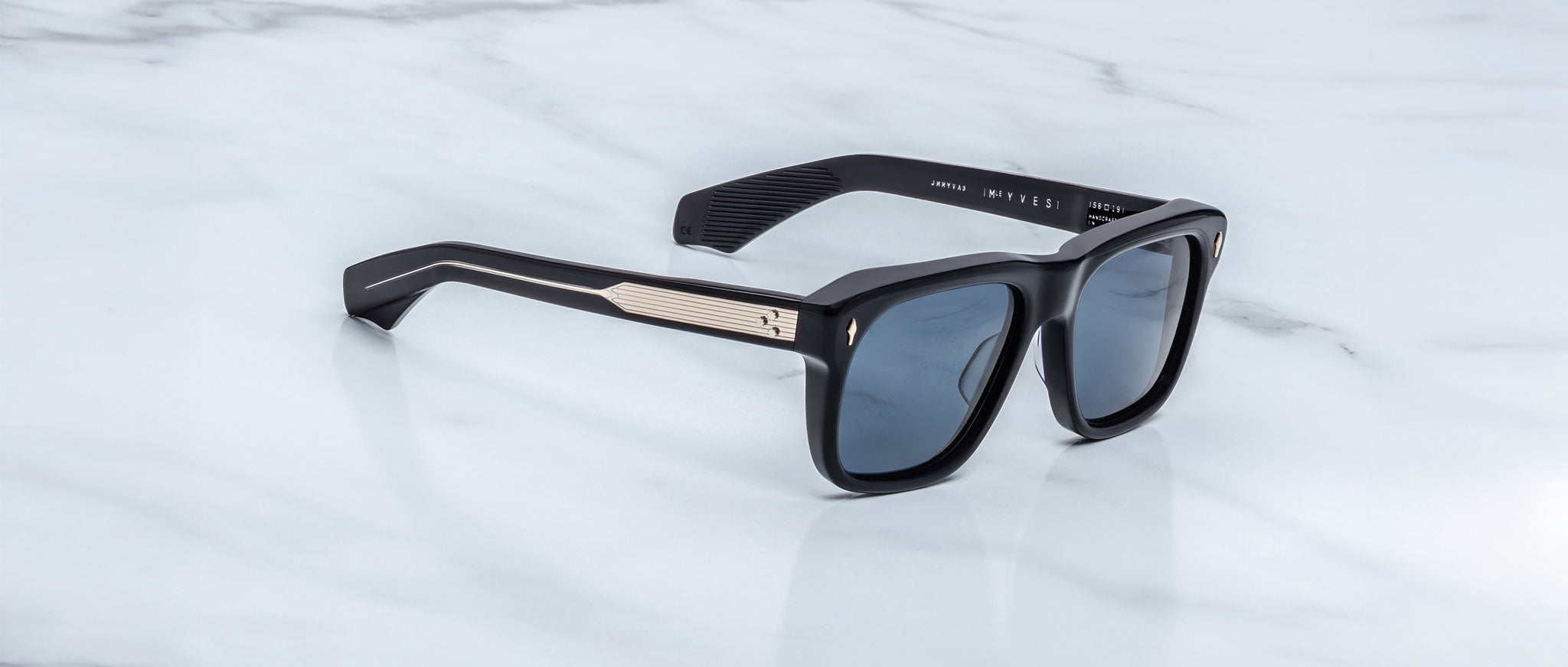 Jacques Marie Mage Yves in Lacquer Blue sunglasses, rectangular dark blue acetate frame with blue-tinted lenses, signature arrowhead rivets, and engraved metal core temples, angled side view