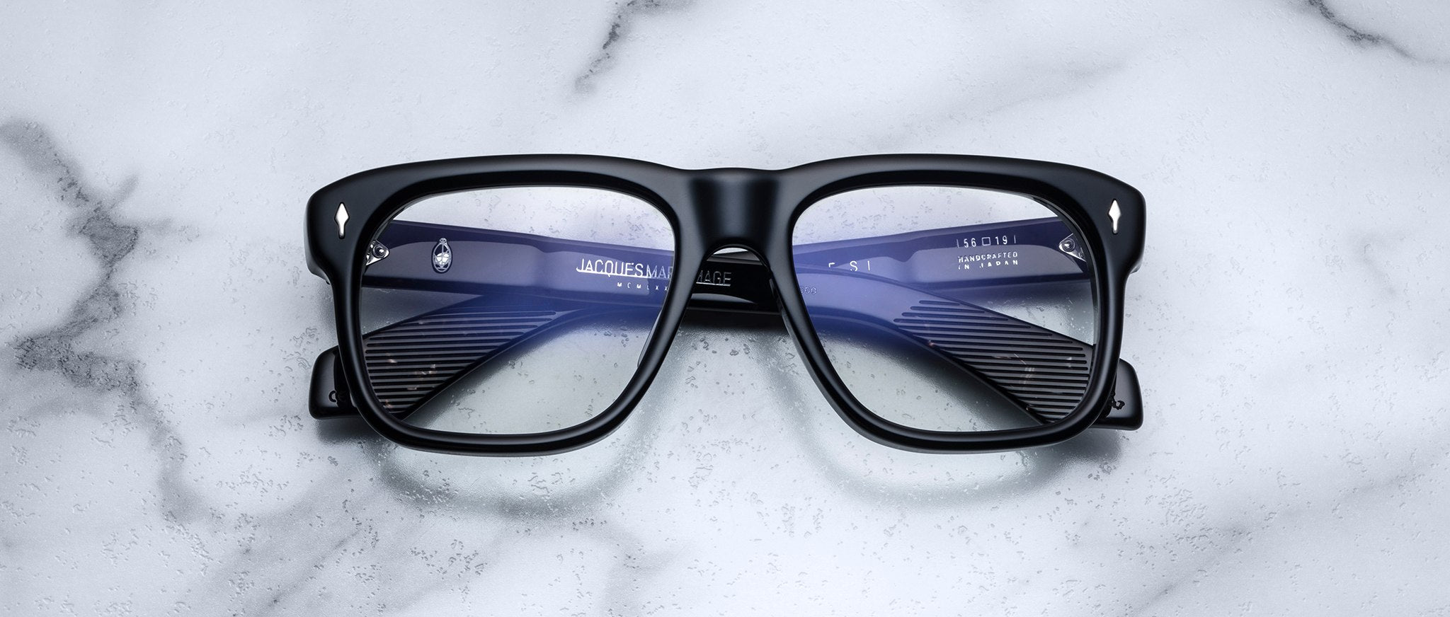 Jacques Marie Mage Yves black rectangular eyeglasses with clear lenses, viewed from above.