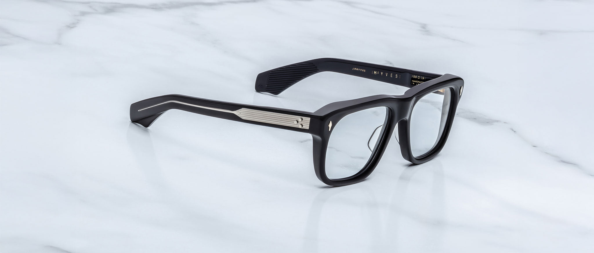 Jacques Marie Mage Yves in Obscure Black optical frame, rectangular matte black acetate frame with clear lenses, signature arrowhead rivets, and engraved metal core temples, angled side view