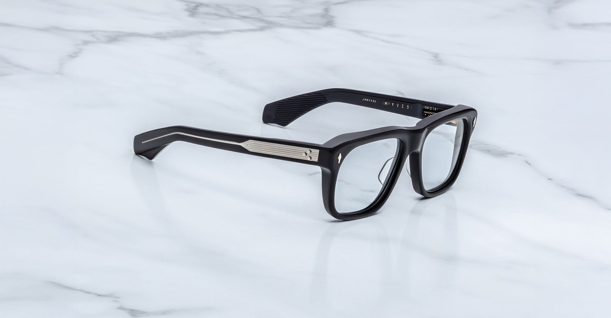 Jacques Marie Mage Yves in Obscure Black optical frame, rectangular matte black acetate frame with clear lenses, signature arrowhead rivets, and engraved metal core temples, angled side view