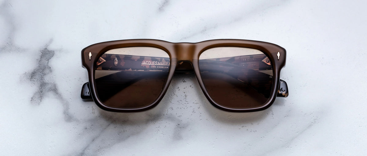 Jacques Marie Mage Yves brown square sunglasses, front view, with cityscape reflected in polarized dark lenses.