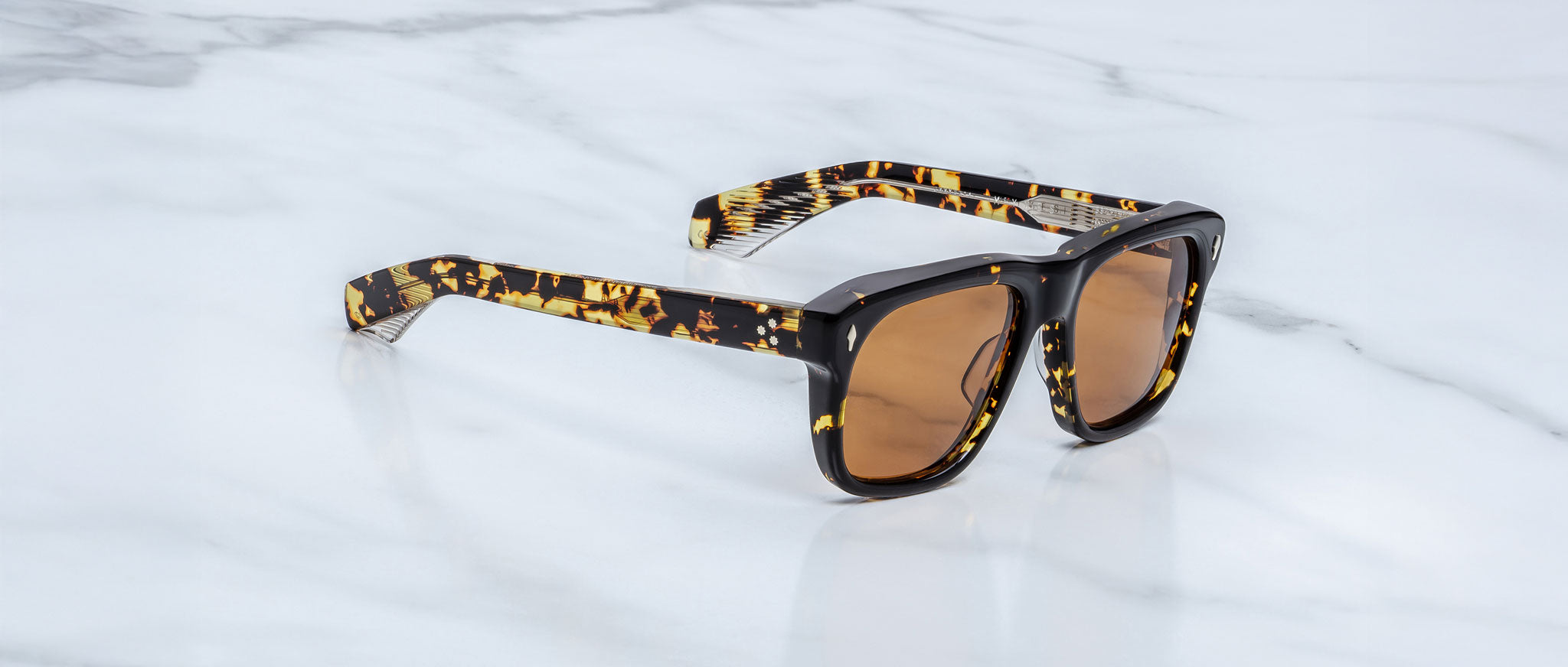 Jacques Marie Mage Yves in Tokyo sunglasses, rectangular black acetate frame with yellow tortoise pattern and amber-tinted lenses, signature arrowhead rivets, angled side view