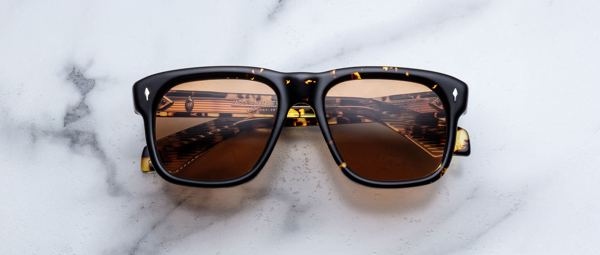 Jacques Marie Mage Yves in Tokyo sunglasses, rectangular black acetate frame with yellow tortoise pattern and amber-tinted lenses and signature arrowhead rivets, front view