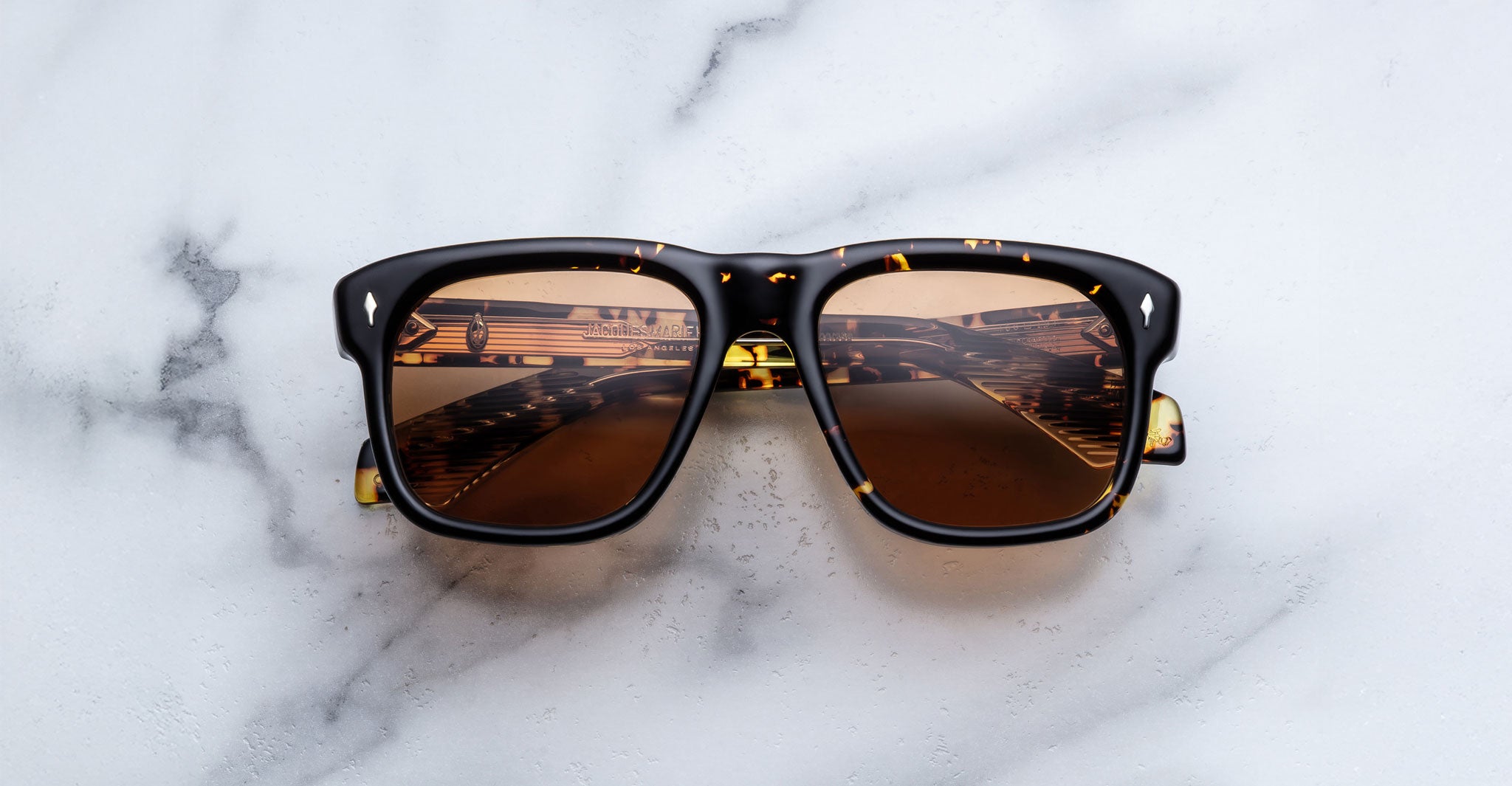 Jacques Marie Mage Yves in Tokyo sunglasses, rectangular black acetate frame with yellow tortoise pattern and amber-tinted lenses and signature arrowhead rivets, front view