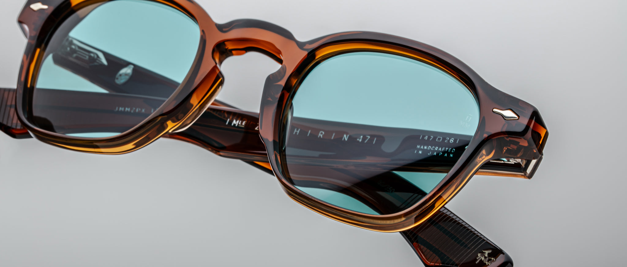 Close-up of Jacques Marie Mage Zephirin 47 eyeglasses in tortoiseshell with blue lenses, inner temple engraving visible.