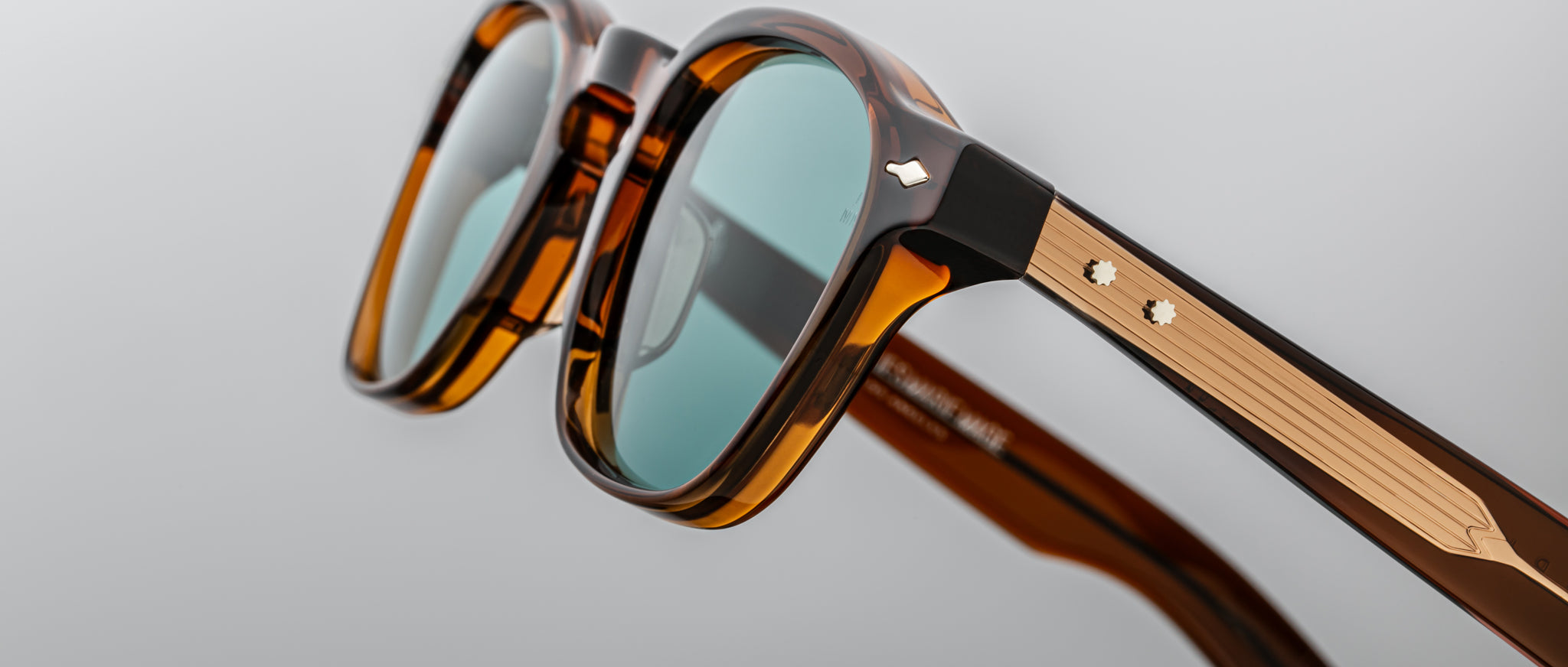 Close-up of Jacques Marie Mage Zephirin 47 sunglasses, showing blue lenses and gold accents from a front angle.