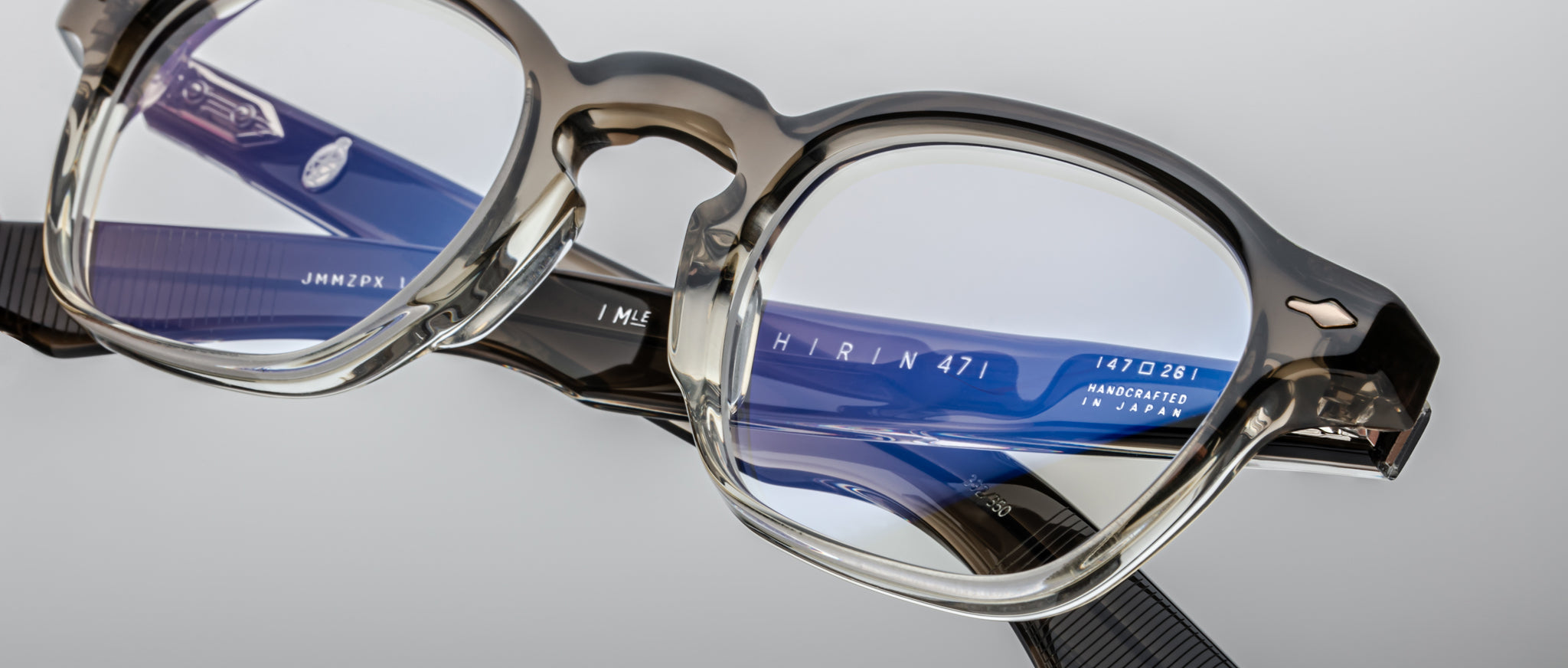 Close-up of Jacques Marie Mage Zephirin 47 eyeglasses in clear and blue acetate, showing inner arm brand markings.