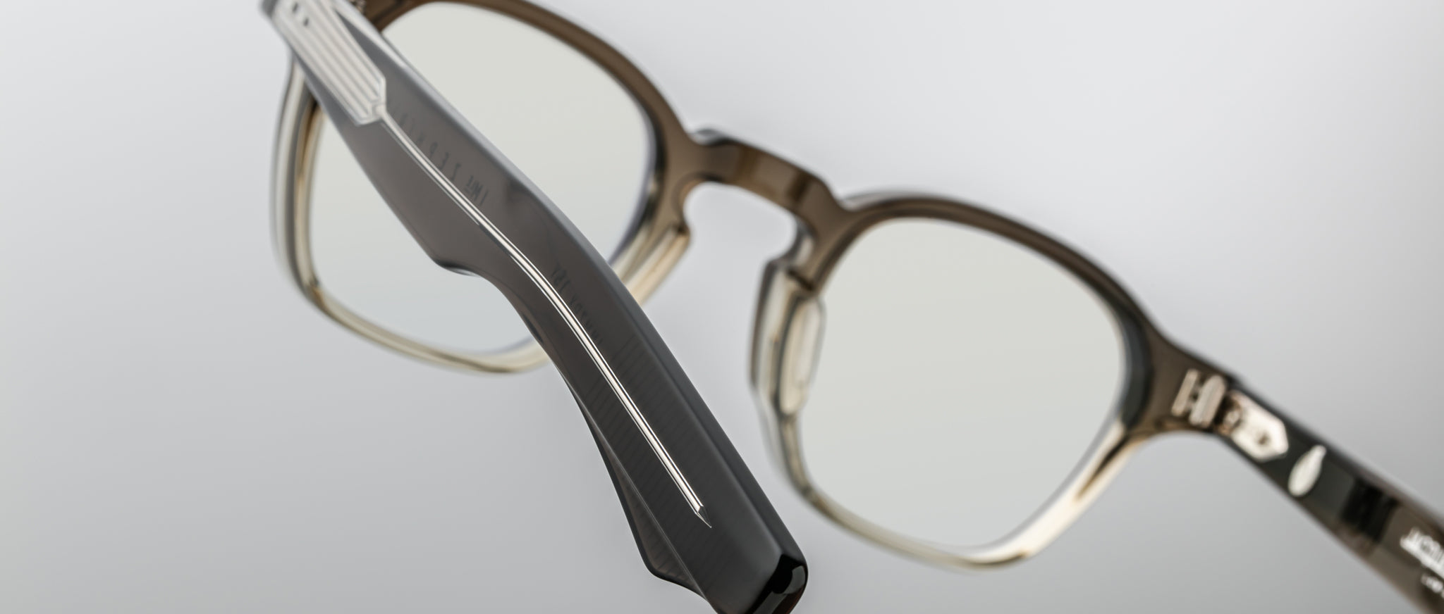 Close-up of Jacques Marie Mage Zephirin 47 eyeglasses featuring translucent brown thick frames and bold silver temple accents.