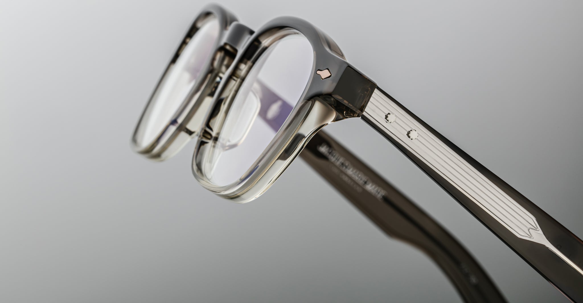 Close-up of Jacques Marie Mage Zephirin 47 eyeglasses, clear frame, silver temple accents, front and side details visible.