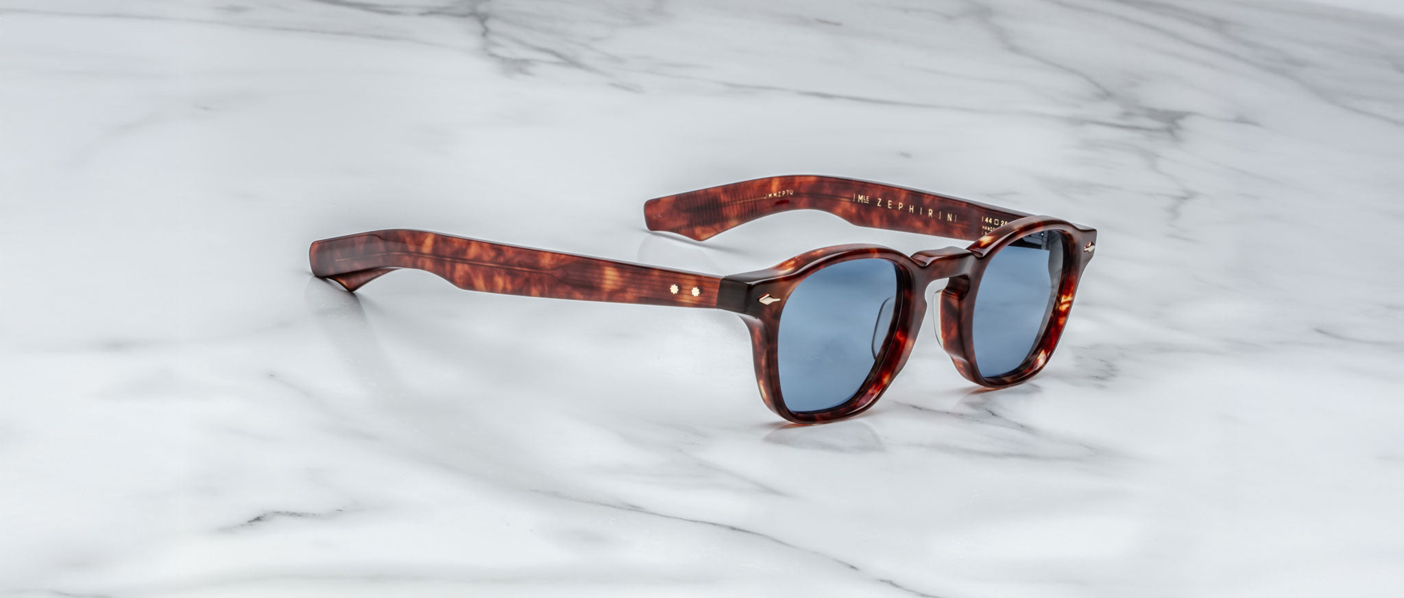 Jacques Marie Mage Zephirin tortoiseshell sunglasses with blue lenses, shown from above.