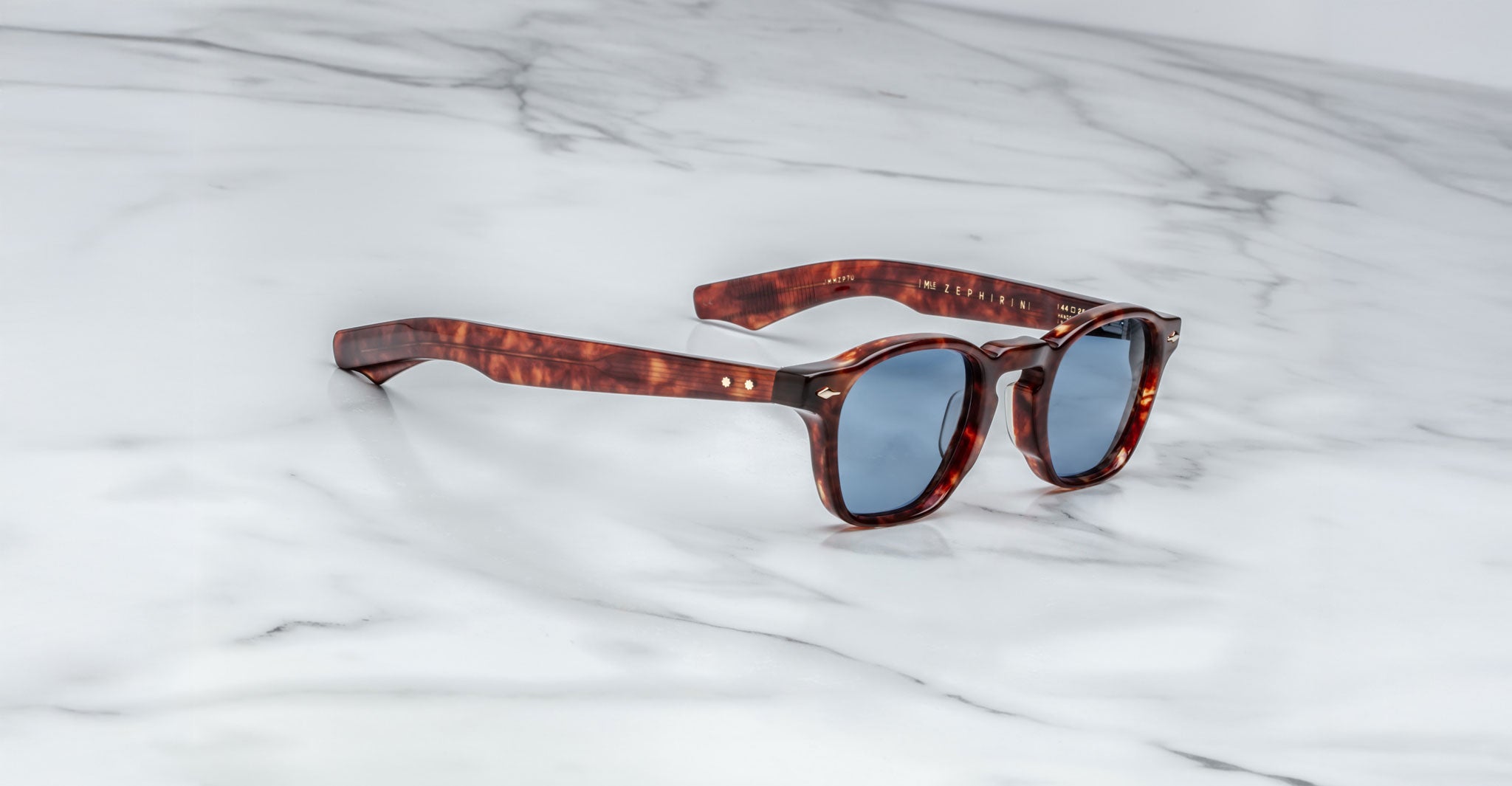 Jacques Marie Mage Zephirin tortoiseshell sunglasses with blue lenses, shown from above.
