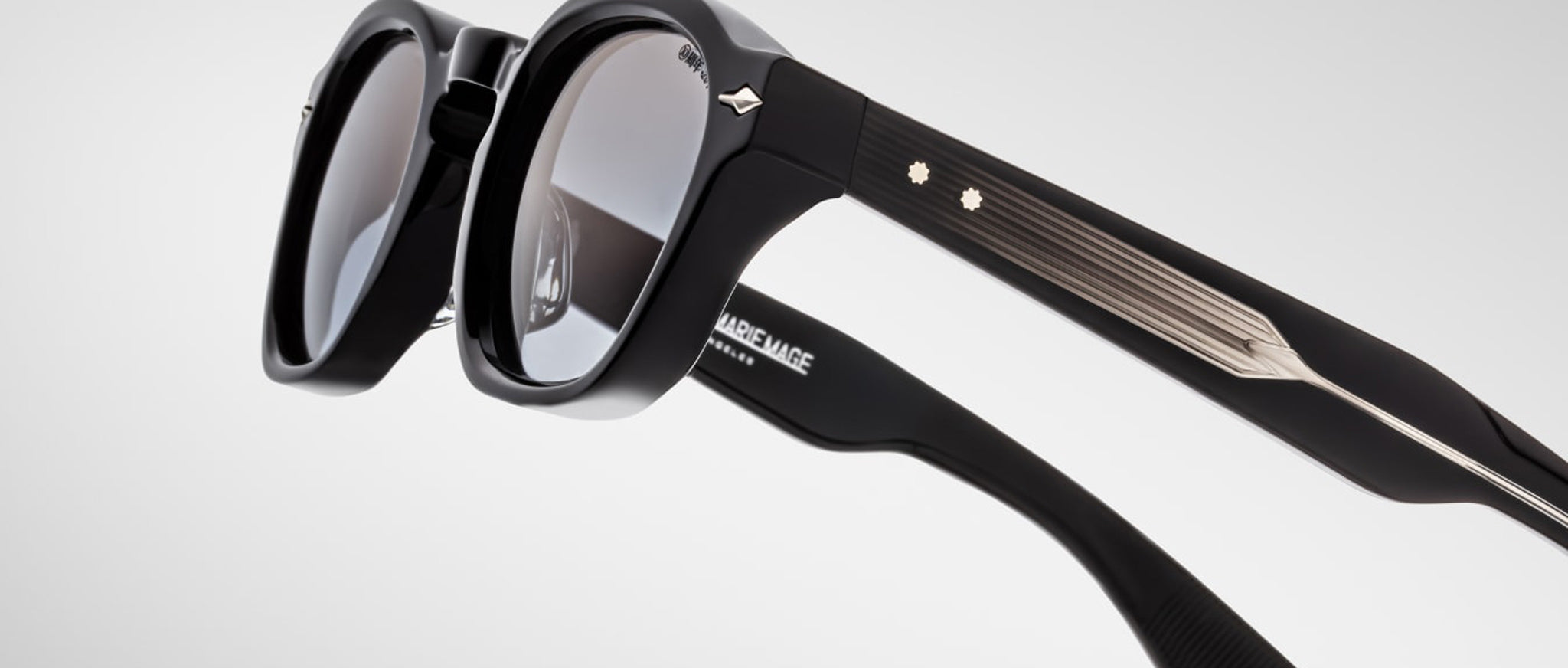 Close-up of Jacques Marie Mage Zephirin sunglasses—black, handcrafted acetate frames with metallic accents and decorative studs, by Jacques Marie Mage.