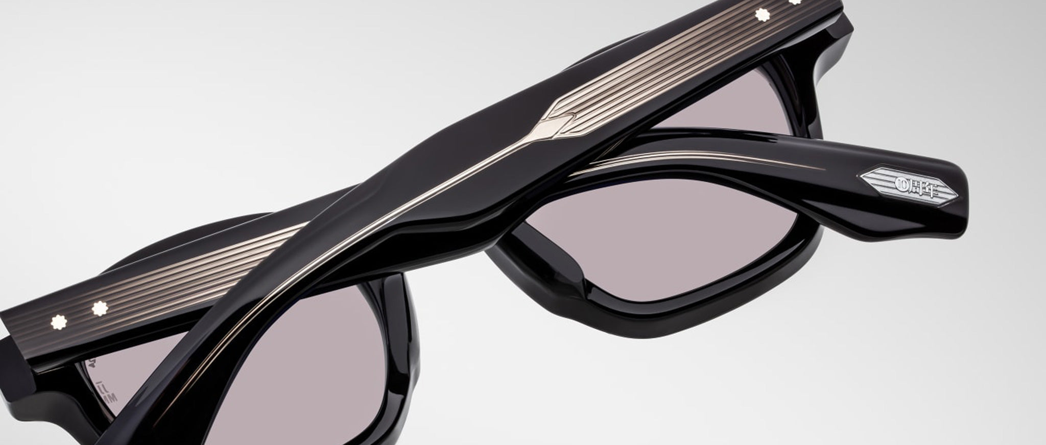 Close-up of Jacques Marie Mage Zephirin sunglasses, featuring engraved details, metallic temple accents, and tinted lenses—luxury handcrafted acetate eyewear by Jacques Marie Mage from a limited edition collection.