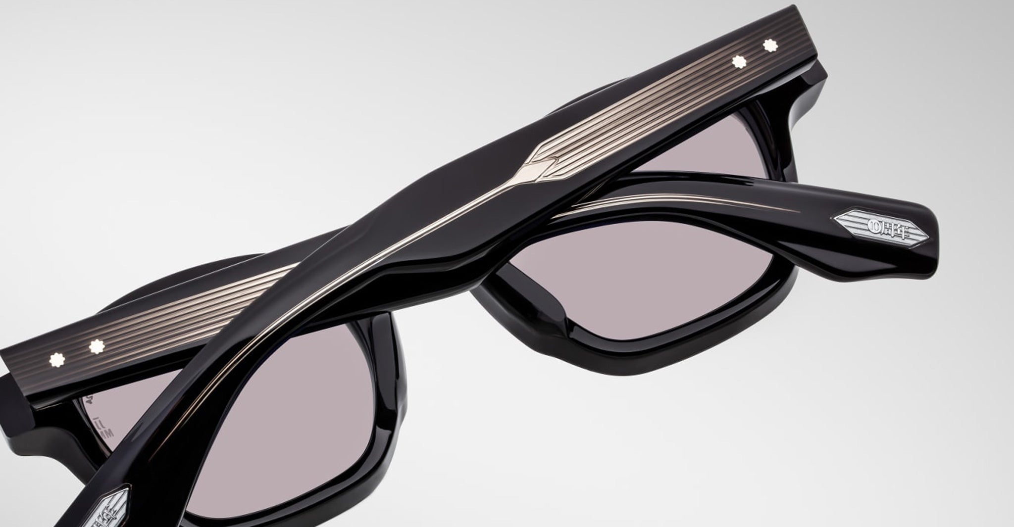 Close-up of Jacques Marie Mage Zephirin sunglasses, featuring engraved details, metallic temple accents, and tinted lenses—luxury handcrafted acetate eyewear by Jacques Marie Mage from a limited edition collection.