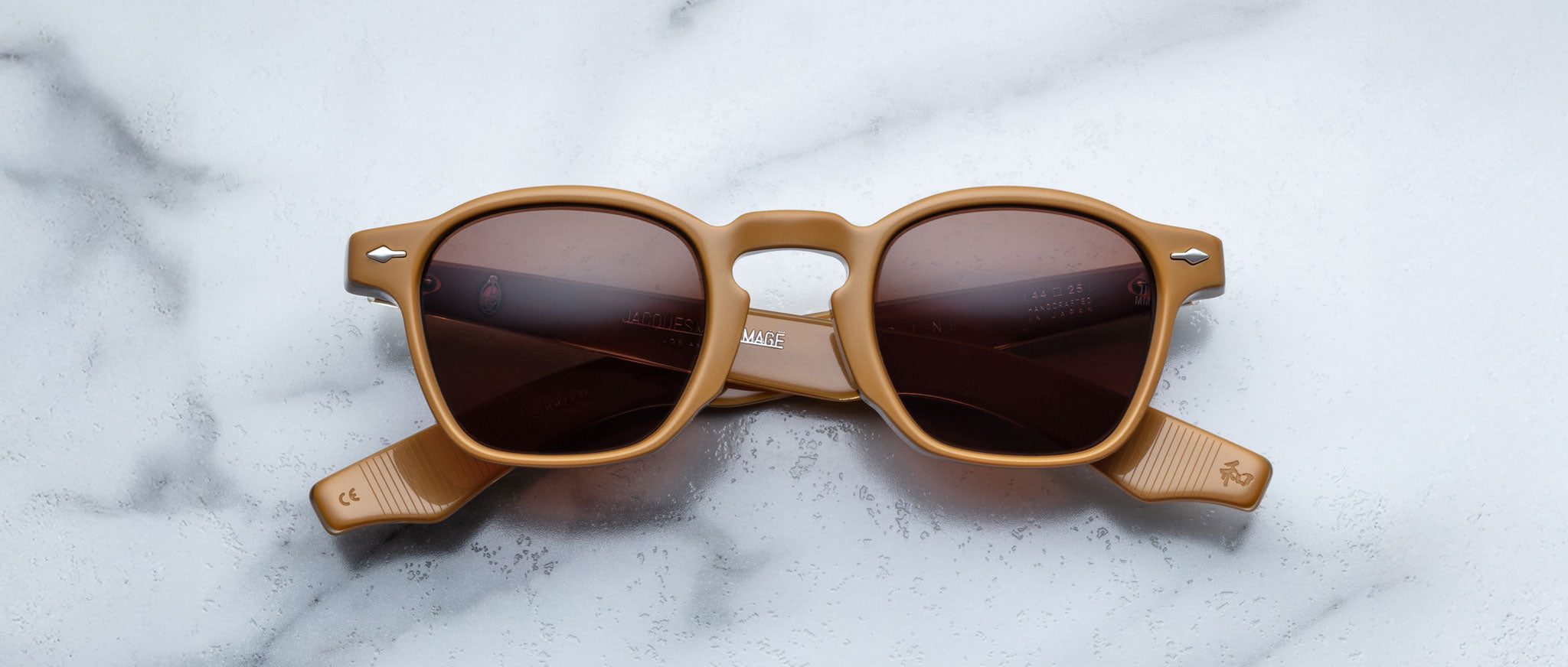 Jacques Marie Mage Zephirin: limited edition light brown handcrafted acetate spectacles with dark lenses, inspired by Jacques Marie Mage, displayed on white marble—a true eyewear statement piece.