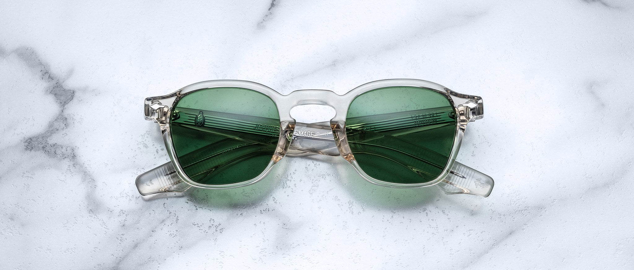 Jacques Marie Mage Zephirin 47 sunglasses with clear frames and green lenses shown from above.