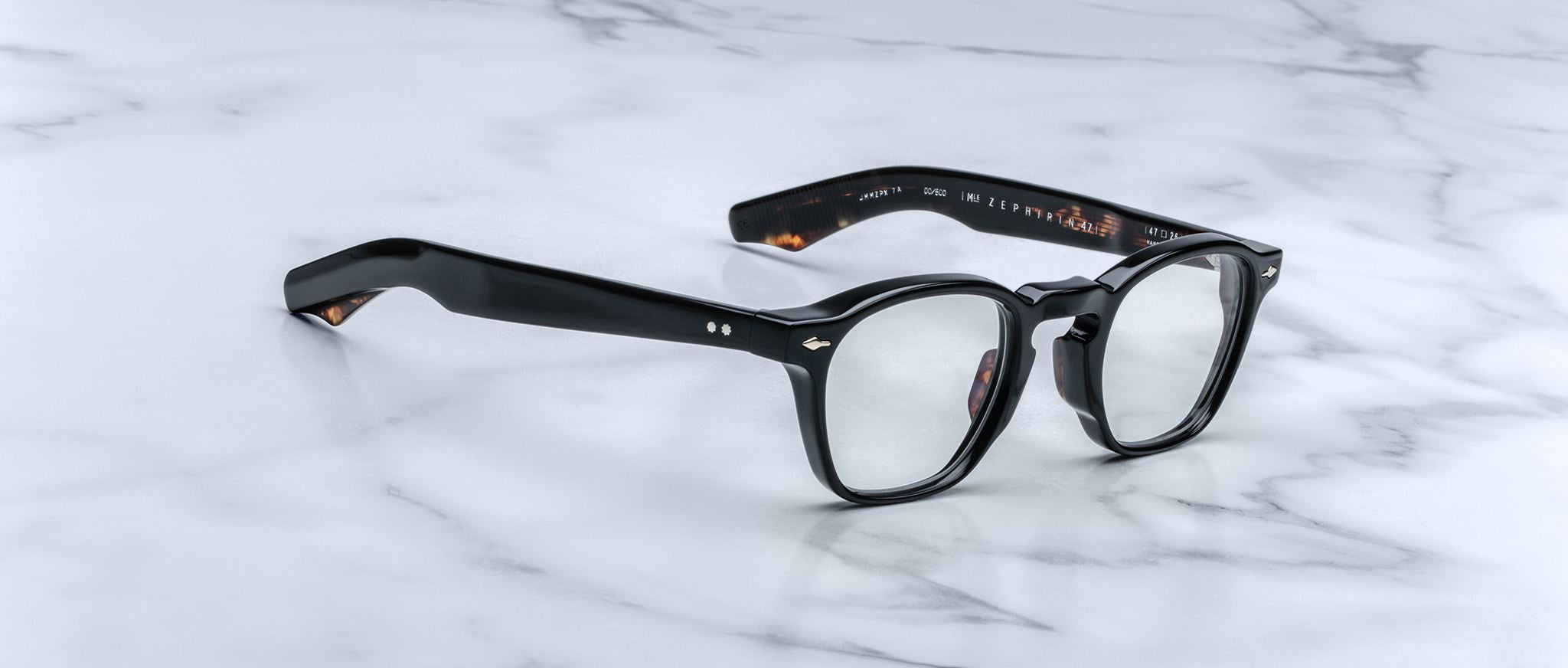 Jacques Marie Mage Zephirin 47 black eyeglasses with clear lenses, lightweight arms partially open, viewed from above.
