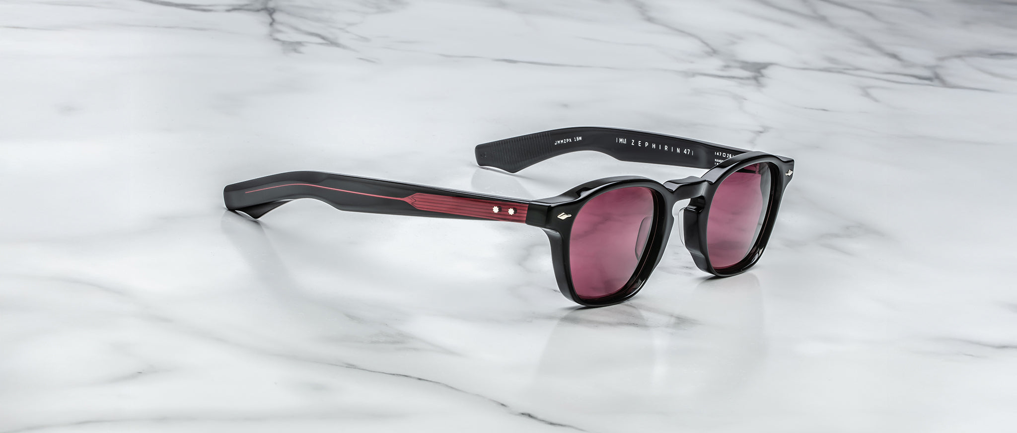 Jacques Marie Mage Zephirin 47 sunglasses with red arms and tinted lenses shown from above.