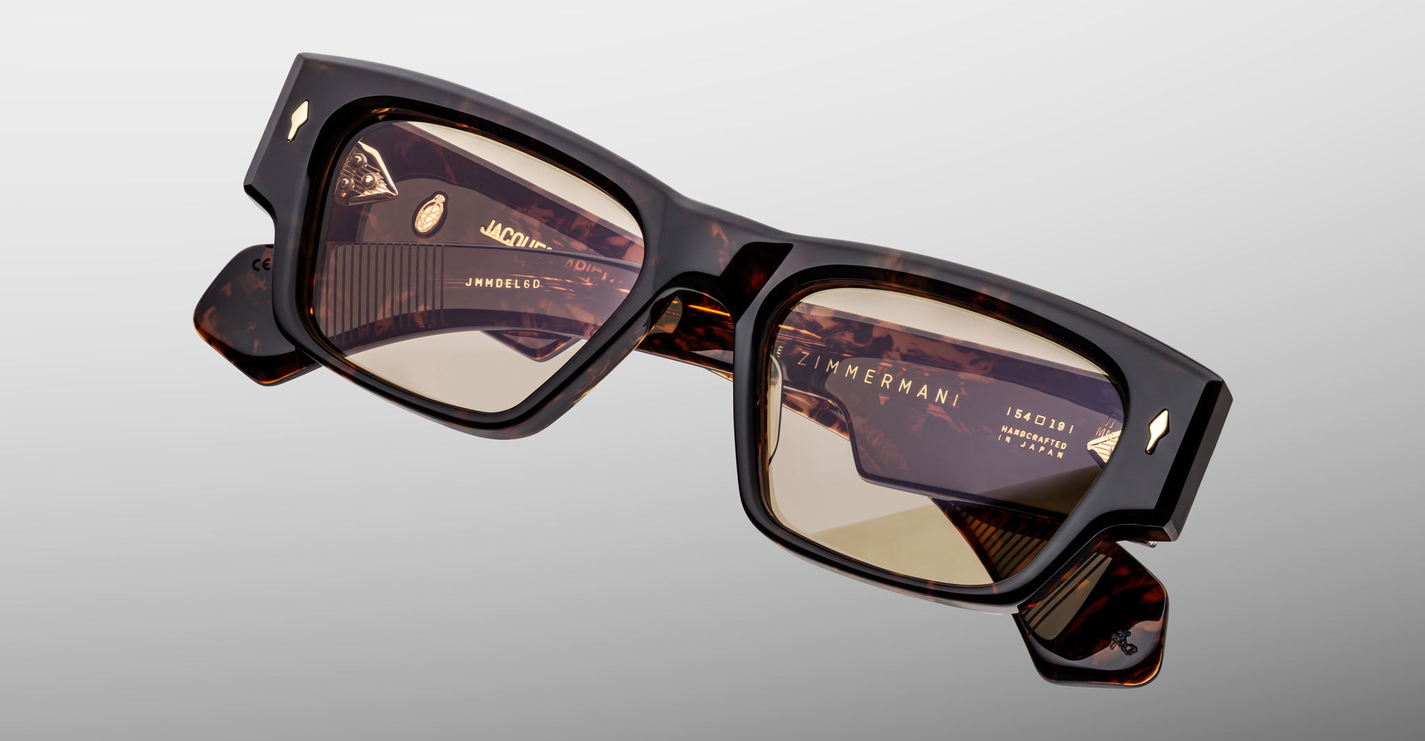 Jacques Marie Mage Zimmerman sunglasses in dark tortoise acetate with rectangular frame, warm tinted lenses, and signature arrowhead pins, angled front view