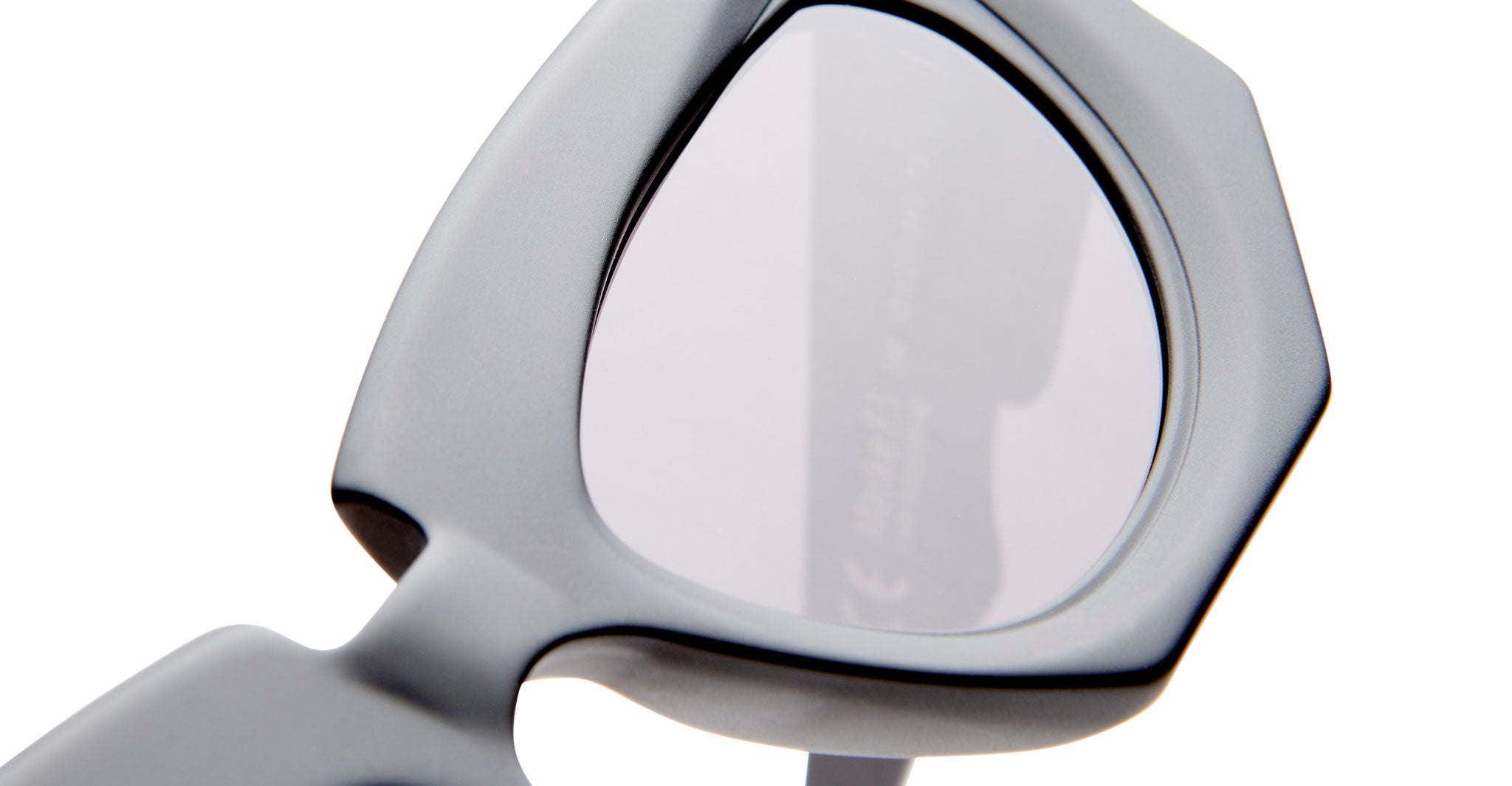 Close-up of KUBORAUM F5 black geometric sunglasses with thick frames and lightly tinted lenses, viewed from the front.