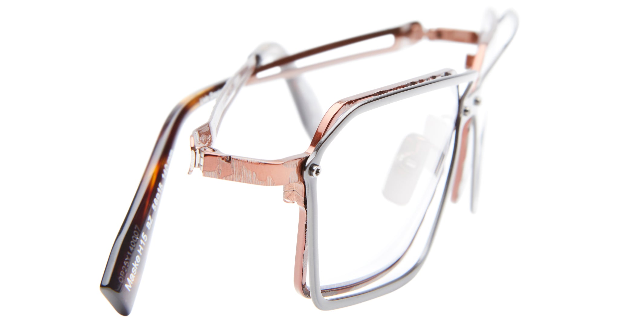 The Kuboraum H15 features a unique double-layered metal frame in rose gold and silver, rectangular lenses, and tortoiseshell-patterned arms for a stylish eyewear look.