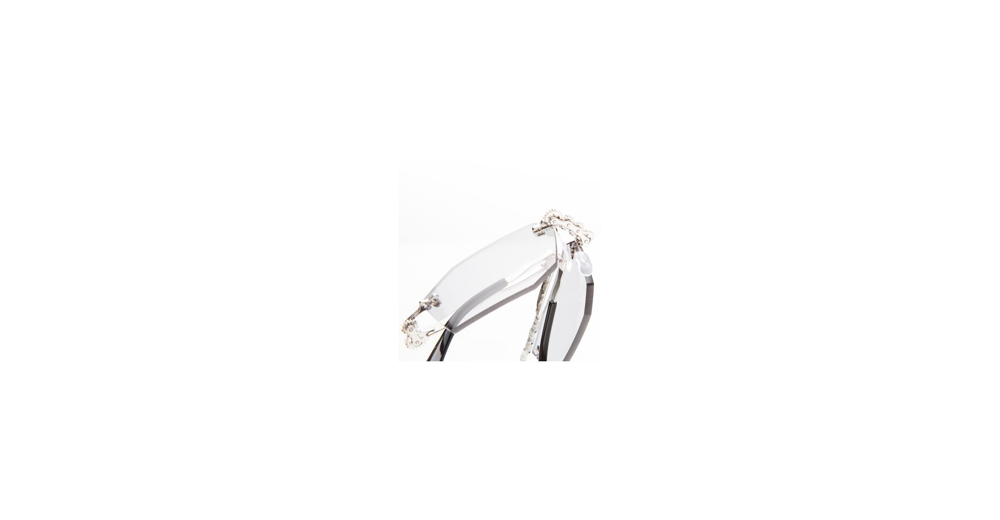 A close-up of the Kuboraum H40 rimless eyeglasses featuring clear lenses and thin metal temples set against a white background.
