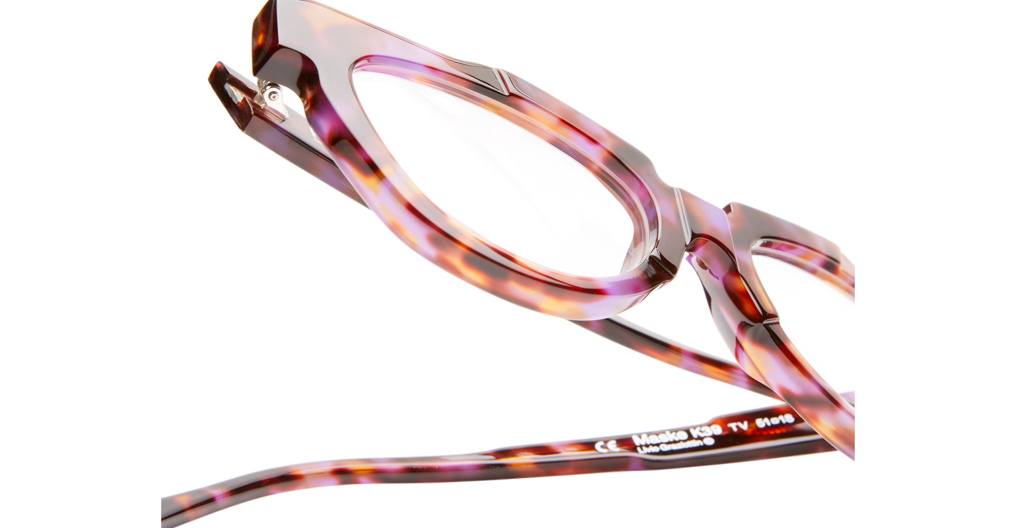 Close-up of Kuboraum K39 eyeglasses with a glossy, multicolored tortoiseshell frame in brown and purple hues. The shot highlights the upper frame and temple arms, emphasizing detailed texture and craftsmanship.