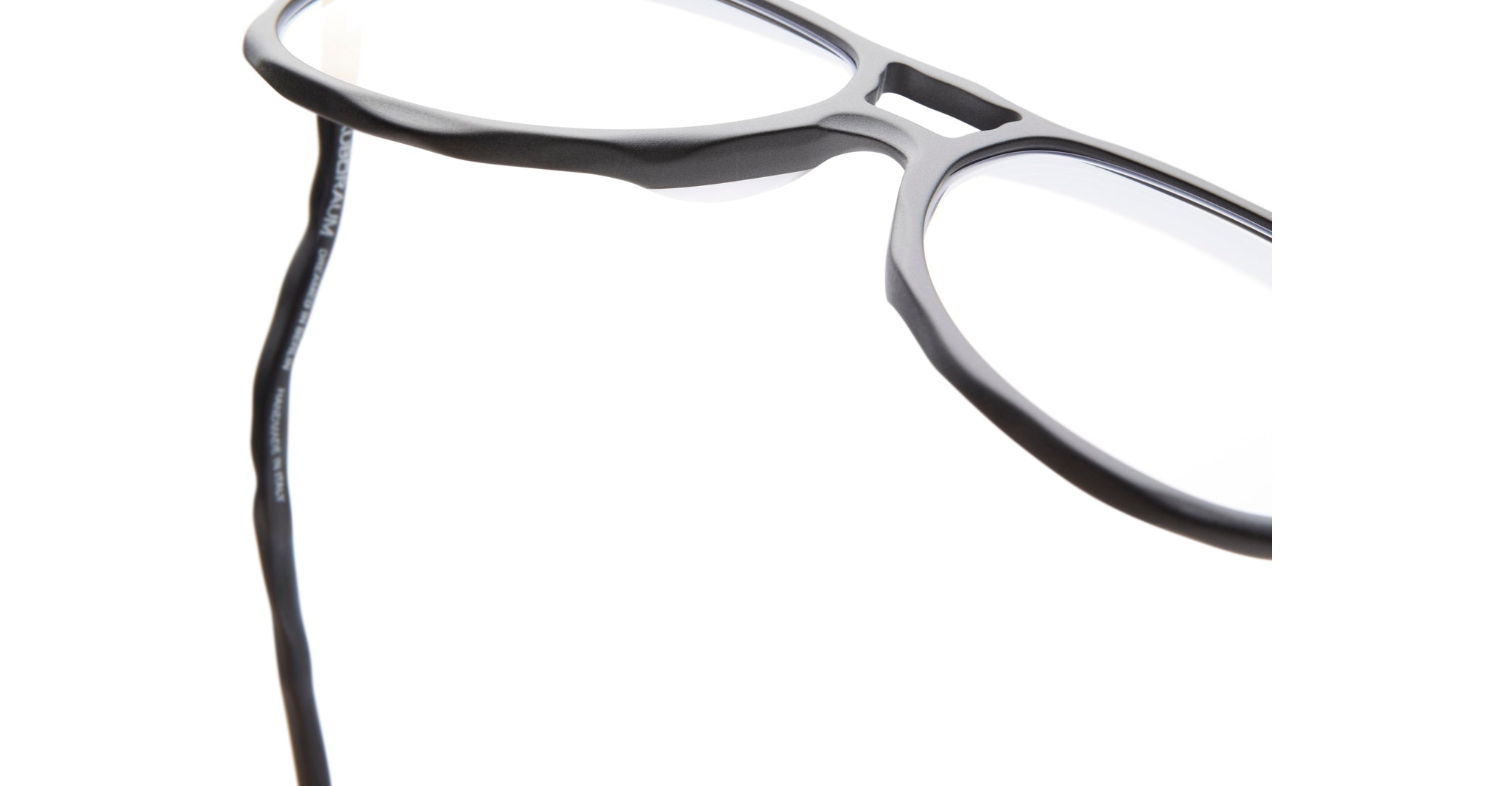 Close-up of KUBORAUM Kuboraum L10 black acetate eyeglasses showing wavy temple design, front and side angle.