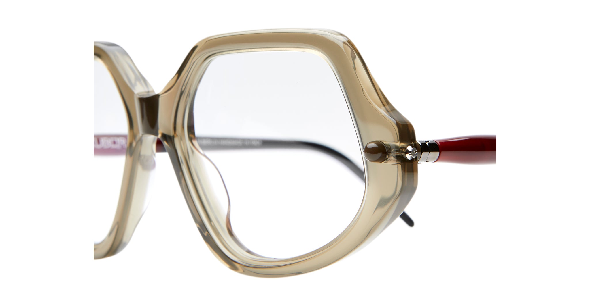 Close-up of Kuboraum P20 oversized eyeglass frames featuring geometric design, transparent beige rims, and red temples against a white background.