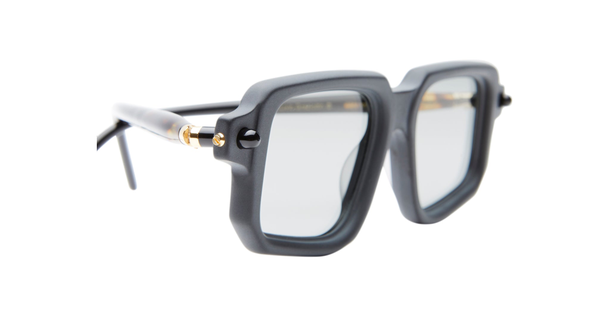 Kuboraum P23 black, square-framed eyeglasses with thick rims and gold detailing on the arms, displayed at an angle on a white background.